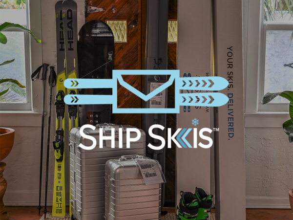 The image shows ski equipment, suitcases, and a pair of ski boots placed near a doorway with the 